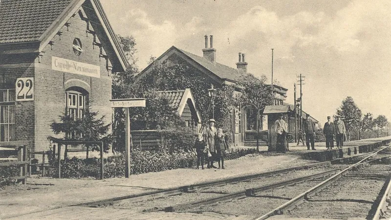 Station Capelle met mensen op het perron en de spoorbaan op de voorgrond.
